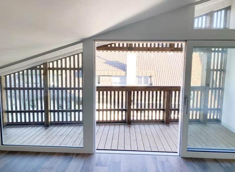 Open wooden balcony with wooden flooring and railings, sliding glass doors