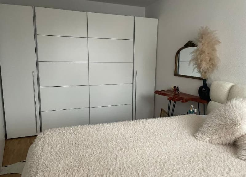 White furniture, bed, bedspread, mirrors, side table, wall decorations
