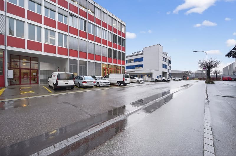 Building exterior with several parked vehicles in front