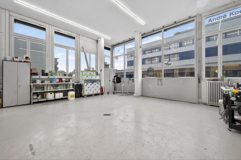 large room, concrete flooring, white walls, large windows, storage units, trolley, cleaning equipment