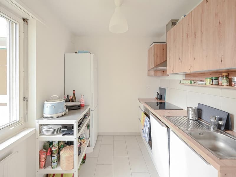 modern kitchen, white tiled floor, white cabinets, stainless steel sink, countertop, gas stove, built-in dishwasher, refrigerator, white shelving unit, window