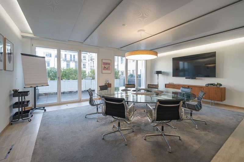 Circular glass table, modern office chairs, carpet, flatscreen TV, sliding doors to terrace, pendant lighting