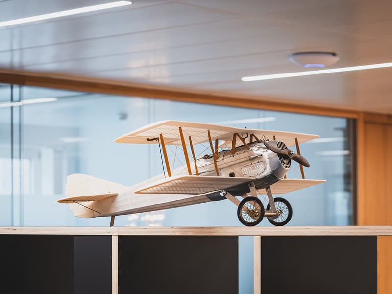 model airplane, wooden desk, glass windows, modern interior