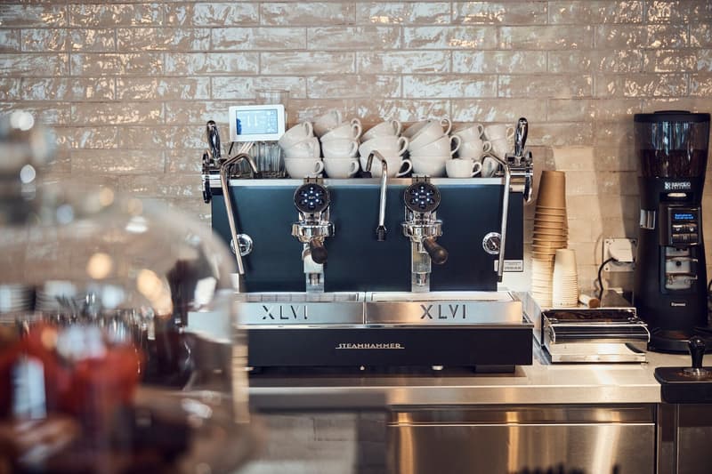 coffee machine on the counter with stacks of cups, espresso machine, glass container with red contents