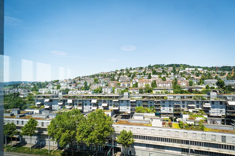 Apartment building with green roofs and a hillside view