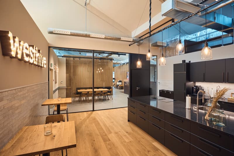 modern kitchen with open dining area, wooden floor, glass walls, 2 tables, hanging lamps