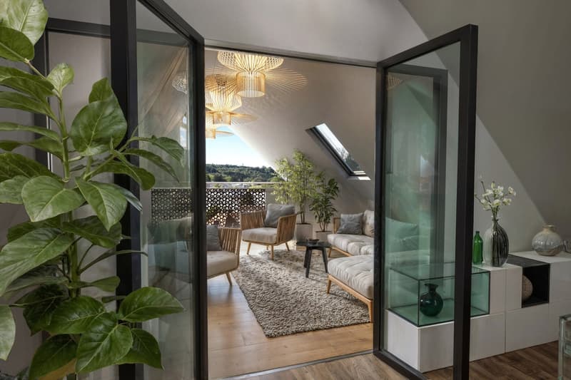 Open room with living area, glass walls, balcony with plants, white furniture, beige rug, large windows, decorative objects