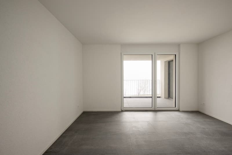 empty room, white walls, gray tiles, sliding glass doors to balcony