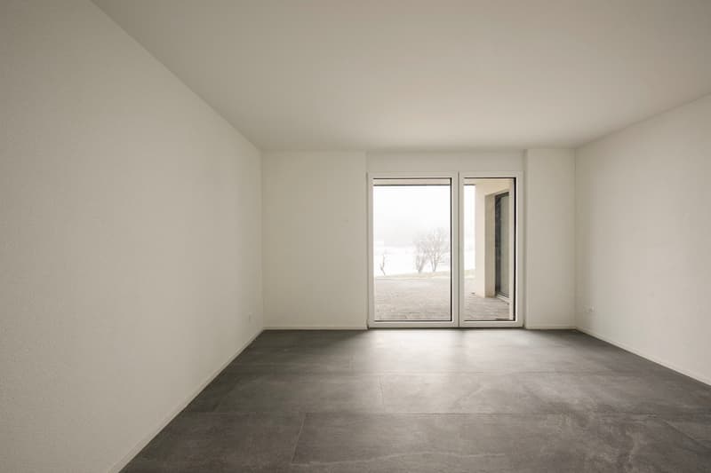 empty room with white walls, tiled floor, sliding glass doors, no furniture