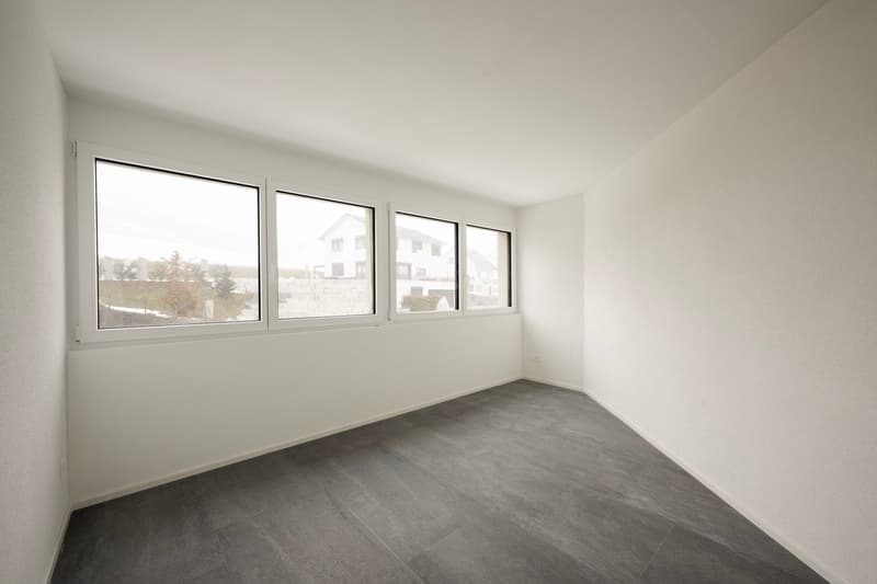 Empty room with white walls and tiled floor, large windows