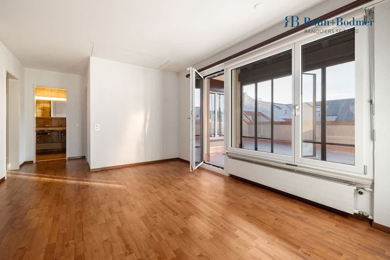 empty room, wooden floor, sliding doors leading to balcony, large windows, white walls, ceiling