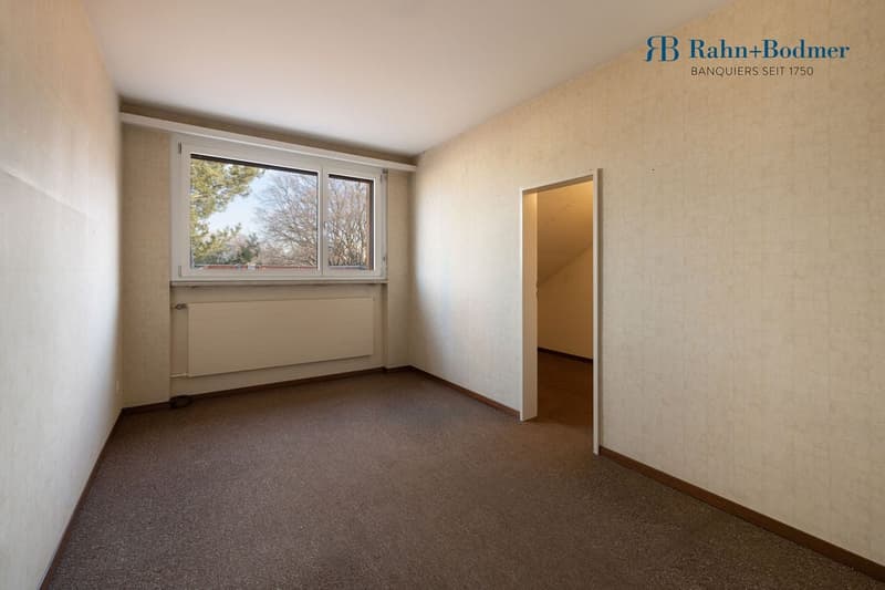 Empty room, windows, carpeted floor, radiator, open door to another room