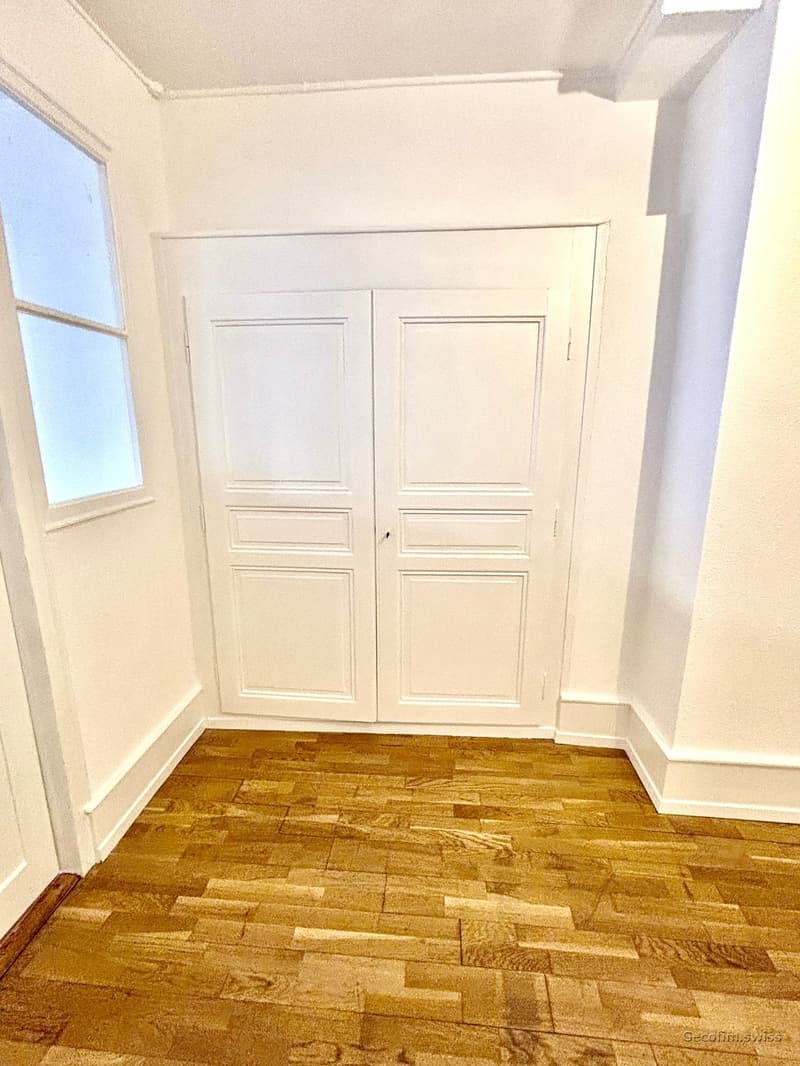 empty room, white walls, wooden floor, double doors, small window