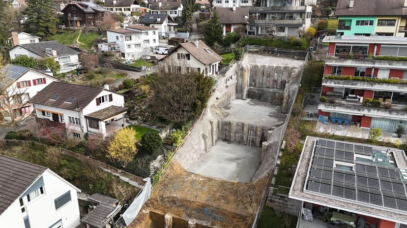 under construction pool, surrounded by residential buildings, large, rectangular, area, solar panels on the roof of the house in the foreground