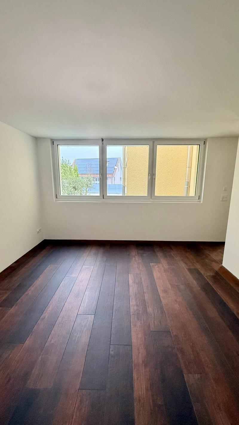 Empty room with wood floor, white walls, window with outside view