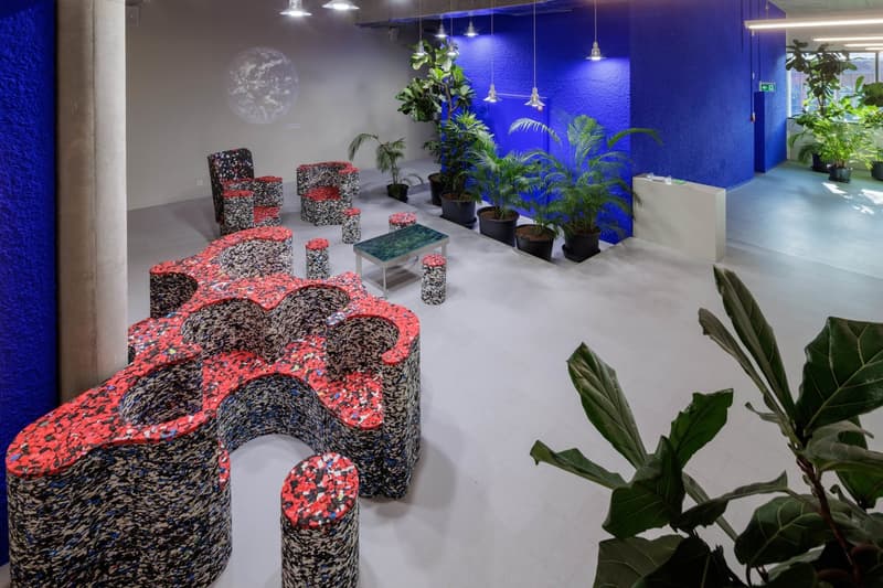 Office room with blue wall, white floor, unique seating arrangement, multiple plants