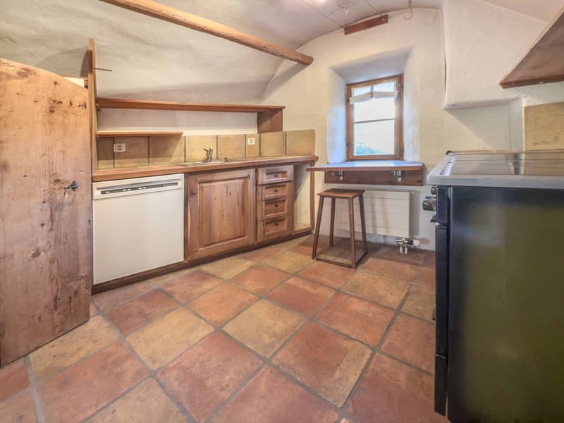 Wooden cupboards, stone tiled floor, dishwasher, radiator, window