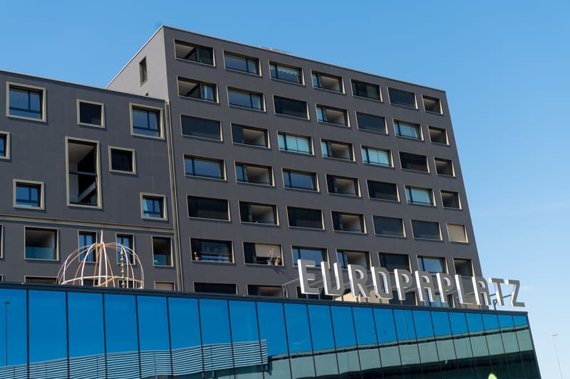 Modern office building with multiple windows, glass facade, signboard reading EUROPLATZ.