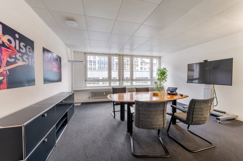 empty room, round table, chairs, TV, plant, cabinets, windows