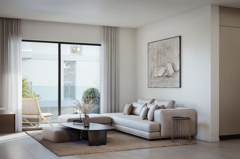 modern living room with large windows, gray sofa, coffee table, side table, rug, artwork