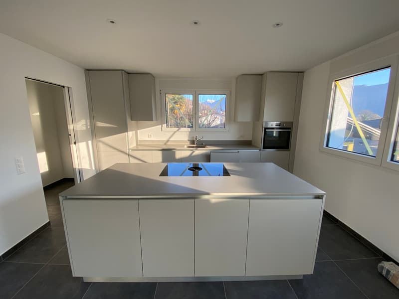 modern white kitchen with a central island, countertops, modern appliances