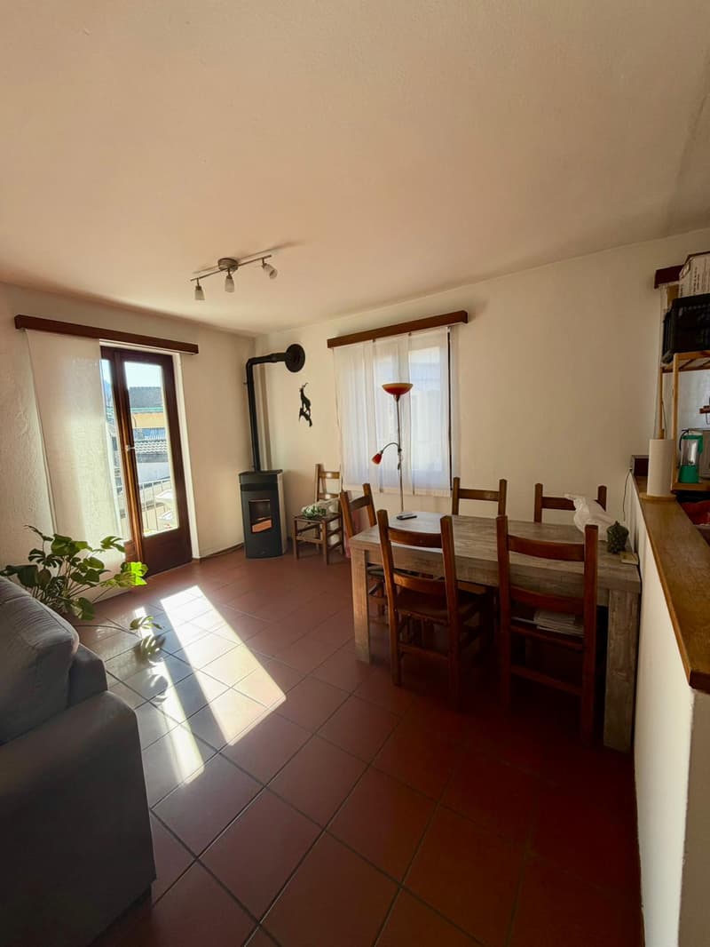 6-seater dining table, dining chairs, white walls, wooden floor, windows with white curtains, fireplace, potted plant, sofa, lamp