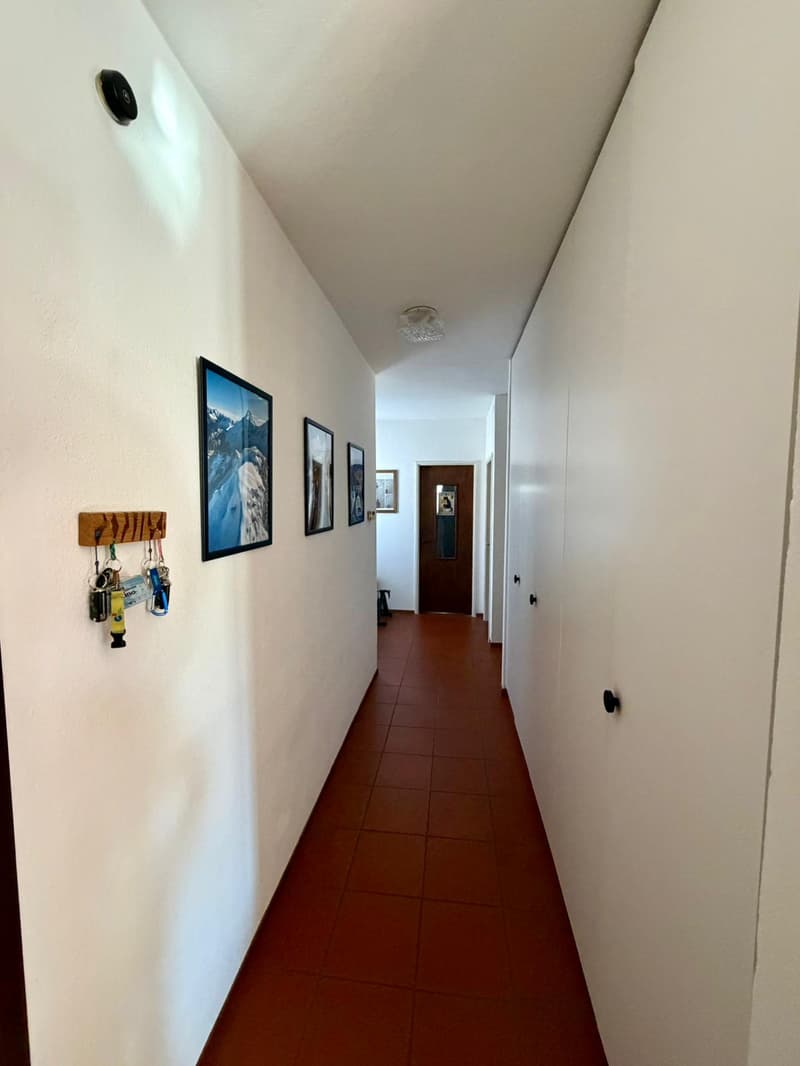 Corridor, red tiles, key rack, picture frames, doors
