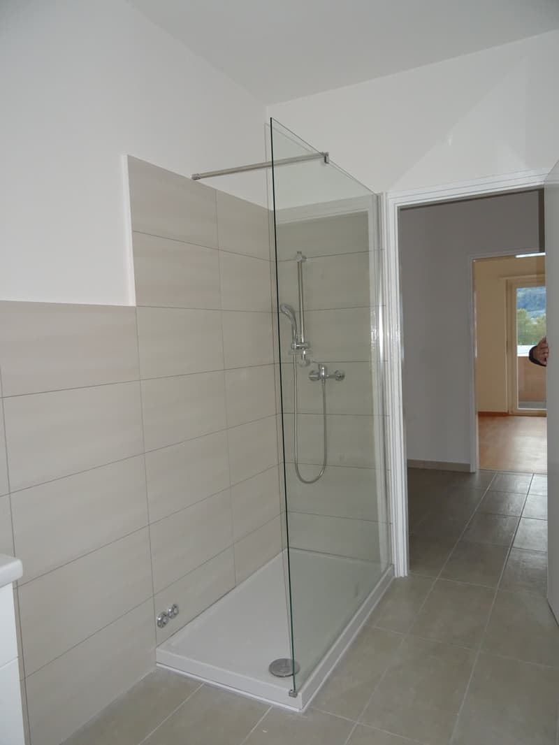 glass shower enclosure, white tiles, floor drain, wall tiles, open door