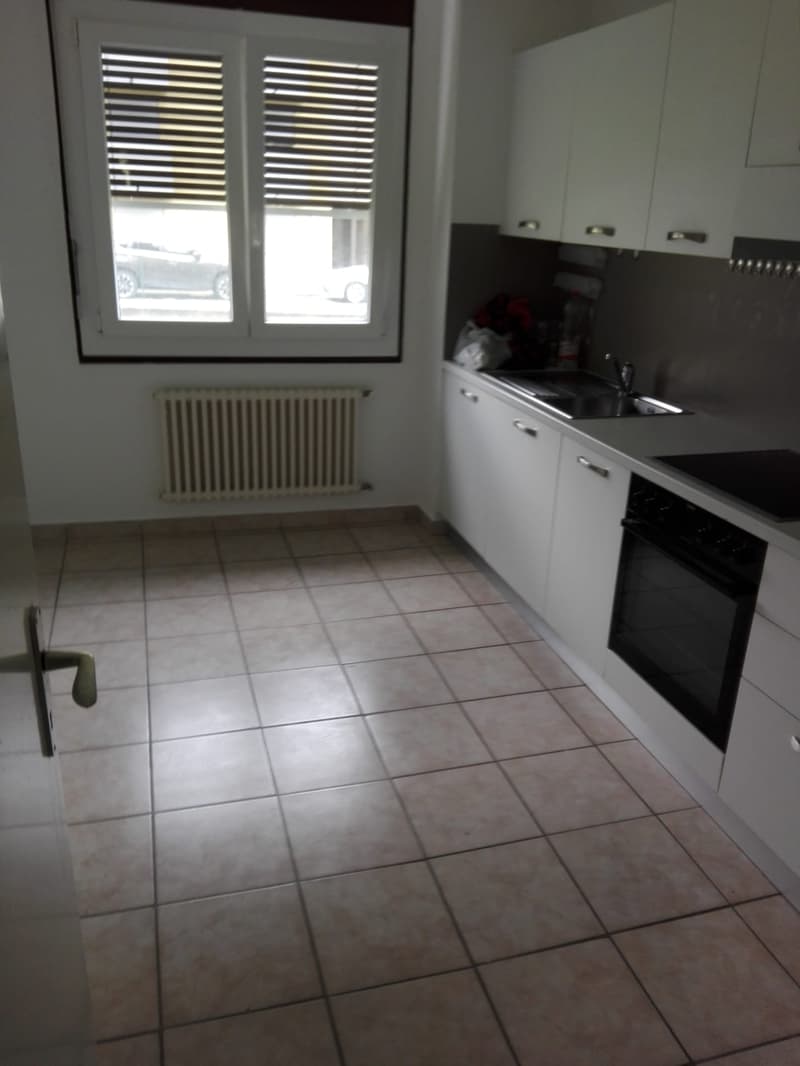 kitchen with white cabinets, tiled floor, window with blinds, radiator, sink, oven, countertop