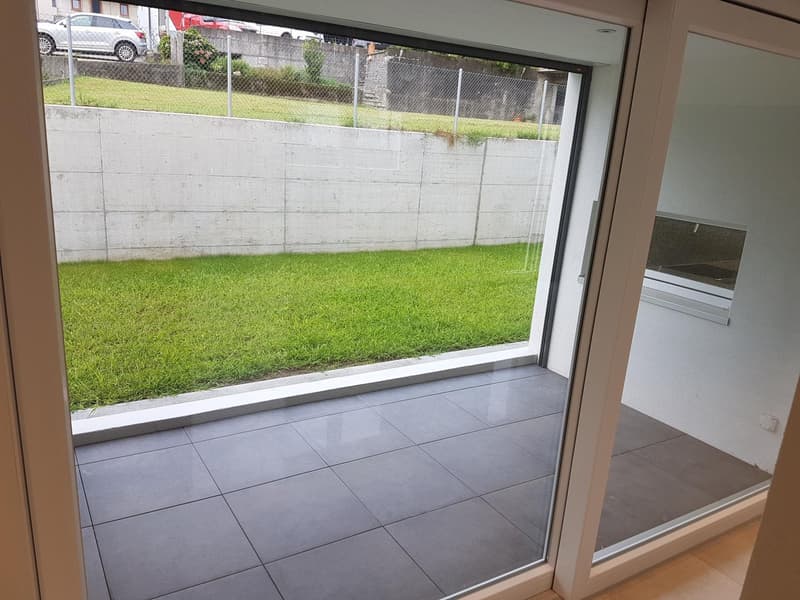 tiled floor, large windows, balcony, view of grassy area