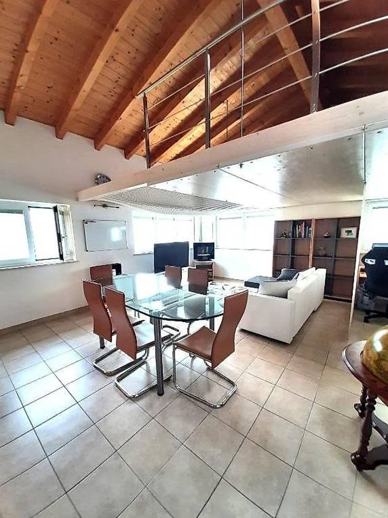 Dining room with glass table, wooden beams, a TV, sofa, wooden desk, and chairs