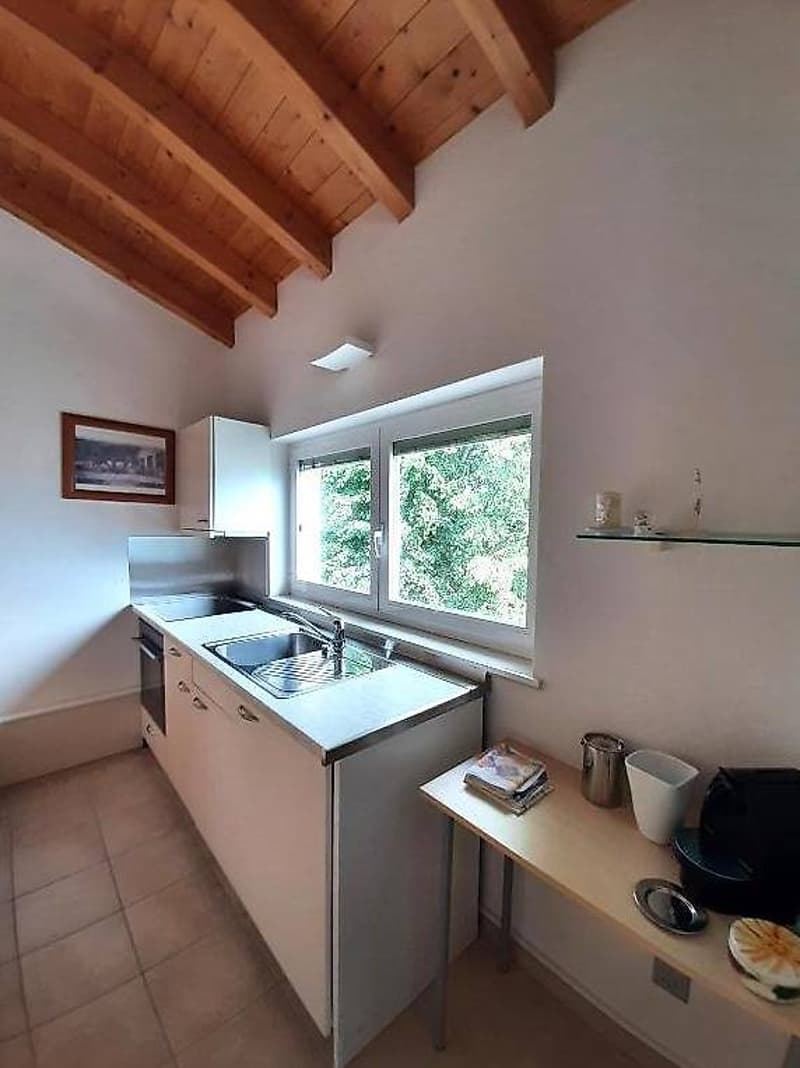modern kitchen with white cabinets, tiled floor, stainless steel sink, faucet, double window, wooden beams on the ceiling