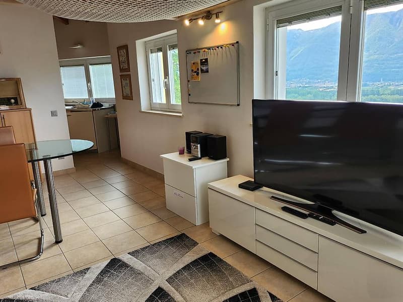 Open living and dining area with windows, modern furniture, and panoramic view.