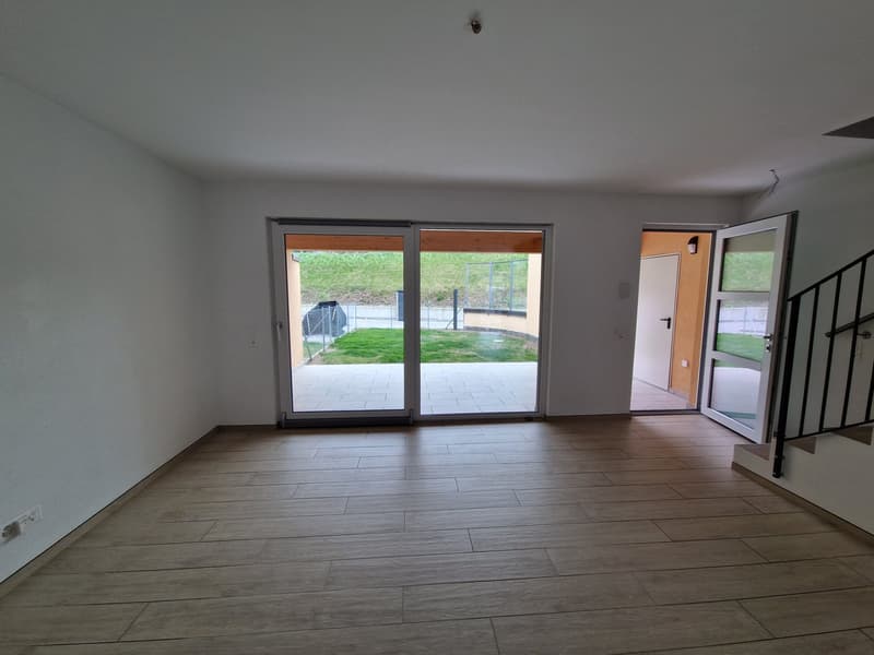 empty room, wooden floor, sliding glass doors, white walls, power outlet, open door