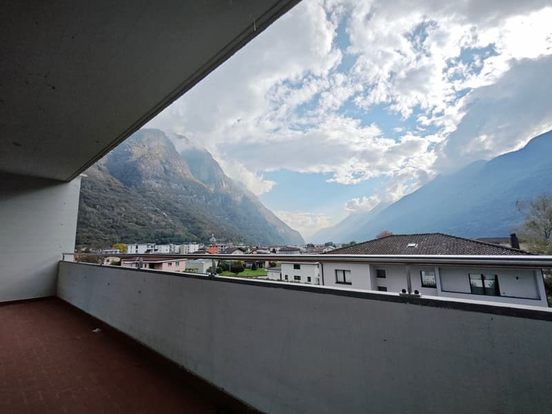 metal railing, red floor, buildings, mountains in the distance