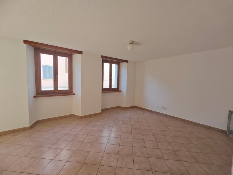 empty room, brown tiled floor, white walls, two wooden windows, single ceiling light