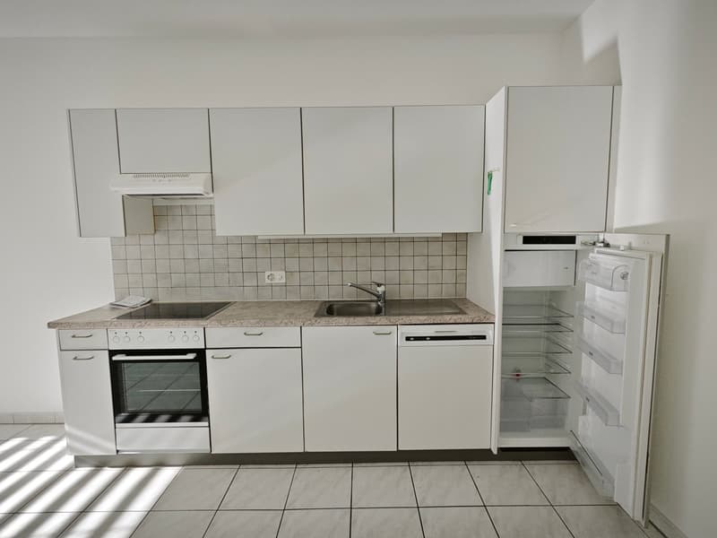 modern kitchen with white cabinets, granite countertop, electric stove, oven, sink, dishwasher, refrigerator, and washing machine
