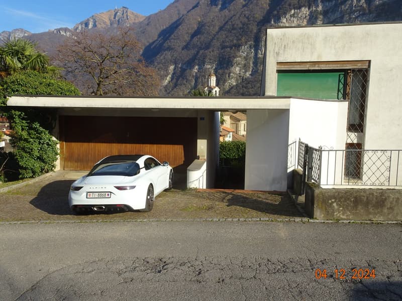 Modern detached house, wooden garage, white car parked, cobblestone driveway, modern architecture, mountain backdrop