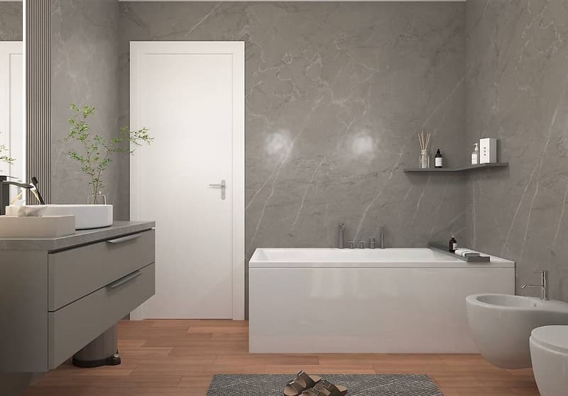 Gray marble tiled walls, wooden floor, white bathtub, white double sink, white toilet, white bidet