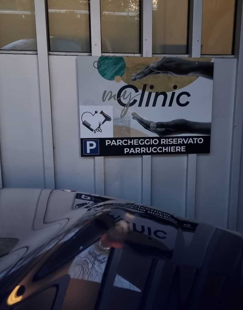 Parking sign and a parked car in front of building