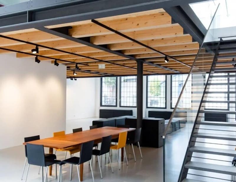 modern interior with wooden beams, glass windows, glass door, staircase, desk, chairs, black cabinets, lamps