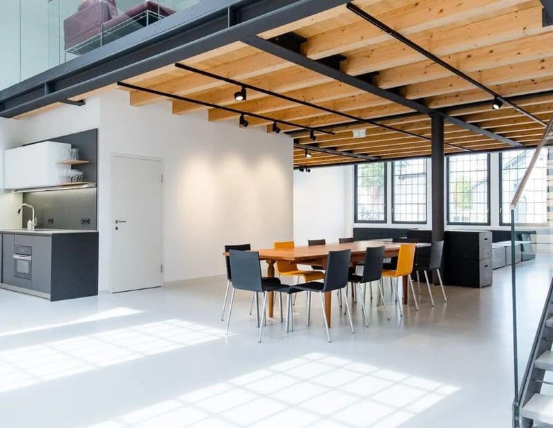modern dining room with large dining table, wooden beams on ceiling, kitchen with appliances and shelves, stairs