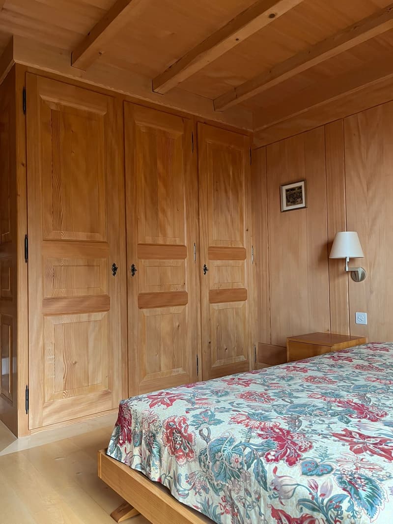 wooden bedroom, bed, wooden headboard, large closet, nightstand, lamp, picture frame