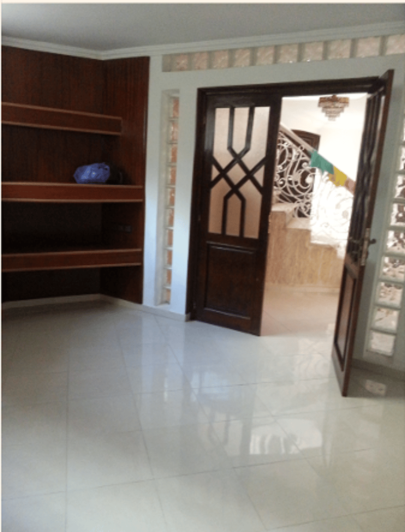Empty room with tiled floor, wooden door, wooden cabinet, open door