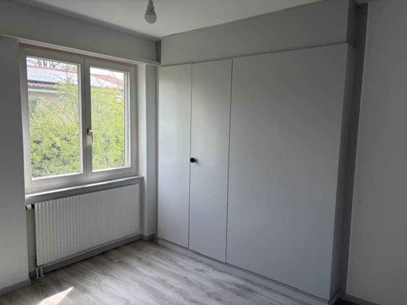 empty room, white walls, wooden floor, white radiator, large window, white wardrobe
