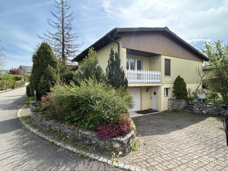 2 story house, yellow exterior, white garage, balcony, driveway, garden
