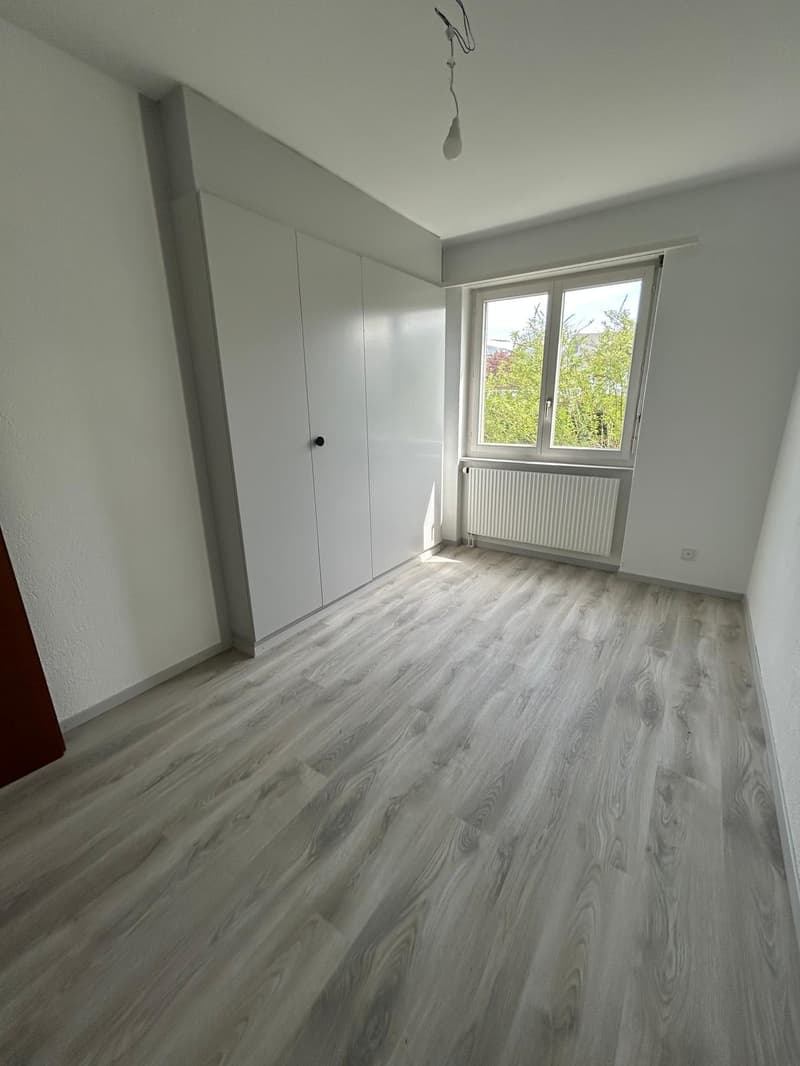 empty room, white walls, wooden floor, large window, white wardrobe, white radiator
