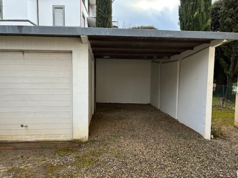 Empty garage with gravel floor and metal roofing