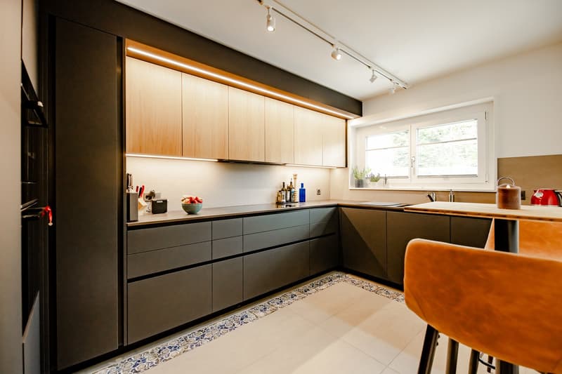 modern kitchen with wooden cabinets, granite countertops, under-cabinet lighting, sink, faucet, window with view