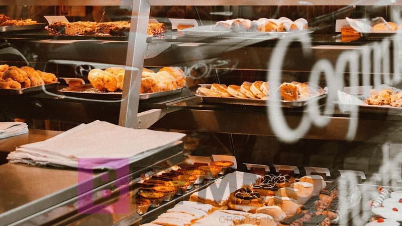Variety of pastries and breads on display in a bakery case